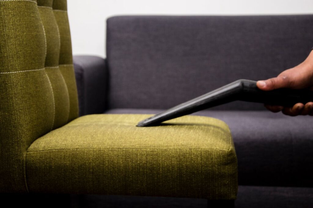 Cleaner Vacuuming a Sofa Chair